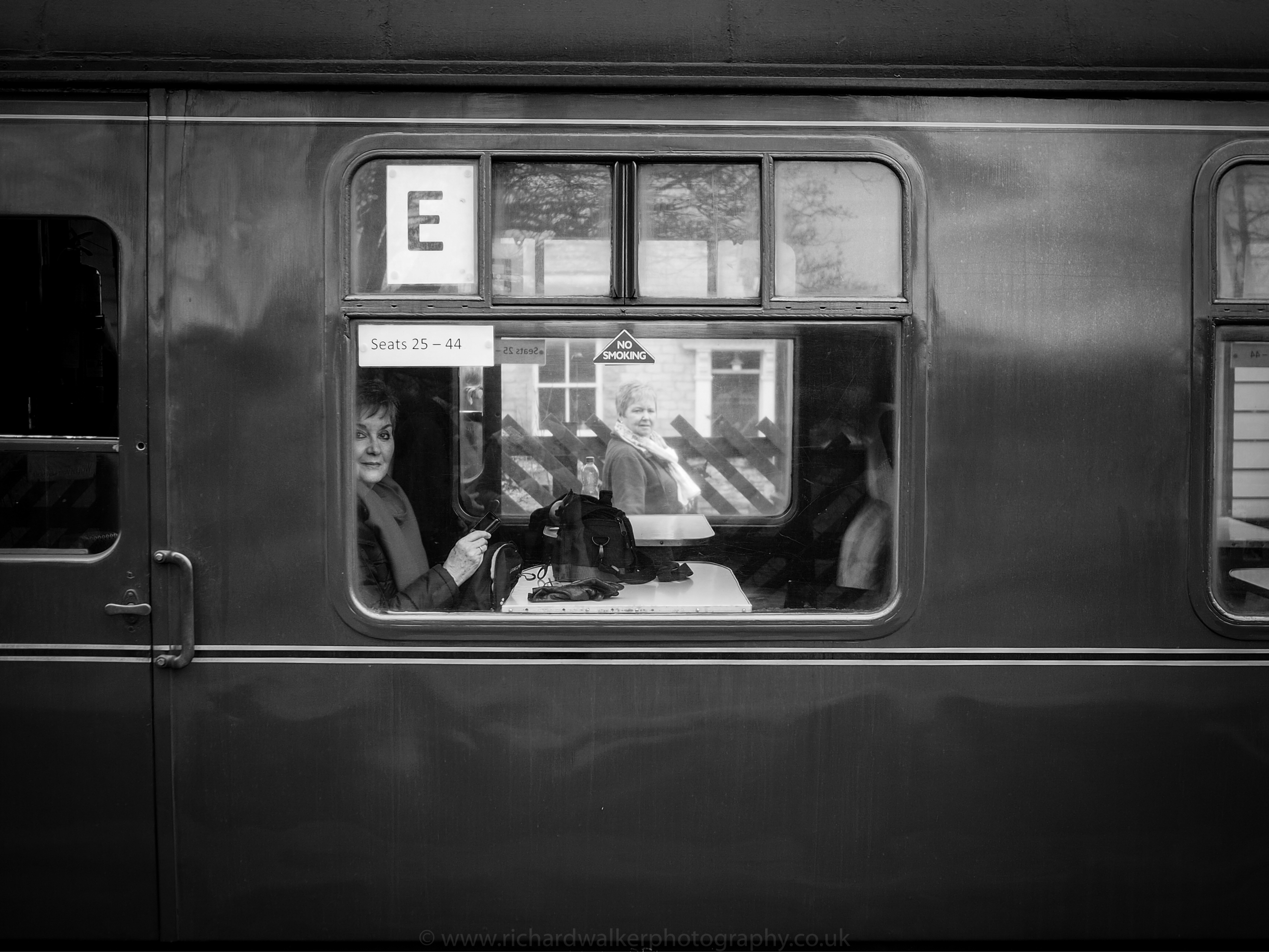 A female passenger sitting on a carriage of the Flying Scotsman looking out of the window